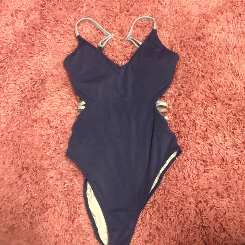 Pink one piece with open sides and back.